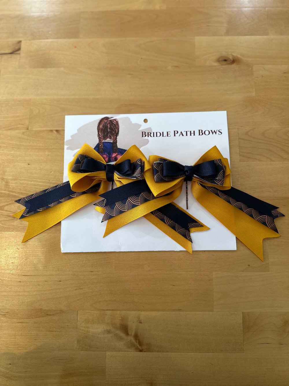 Image of children’s horse riding show bows, yellow black and gold pattern design