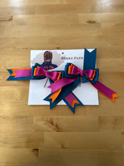 Image of children’s horse riding show bows, orange blue and pink