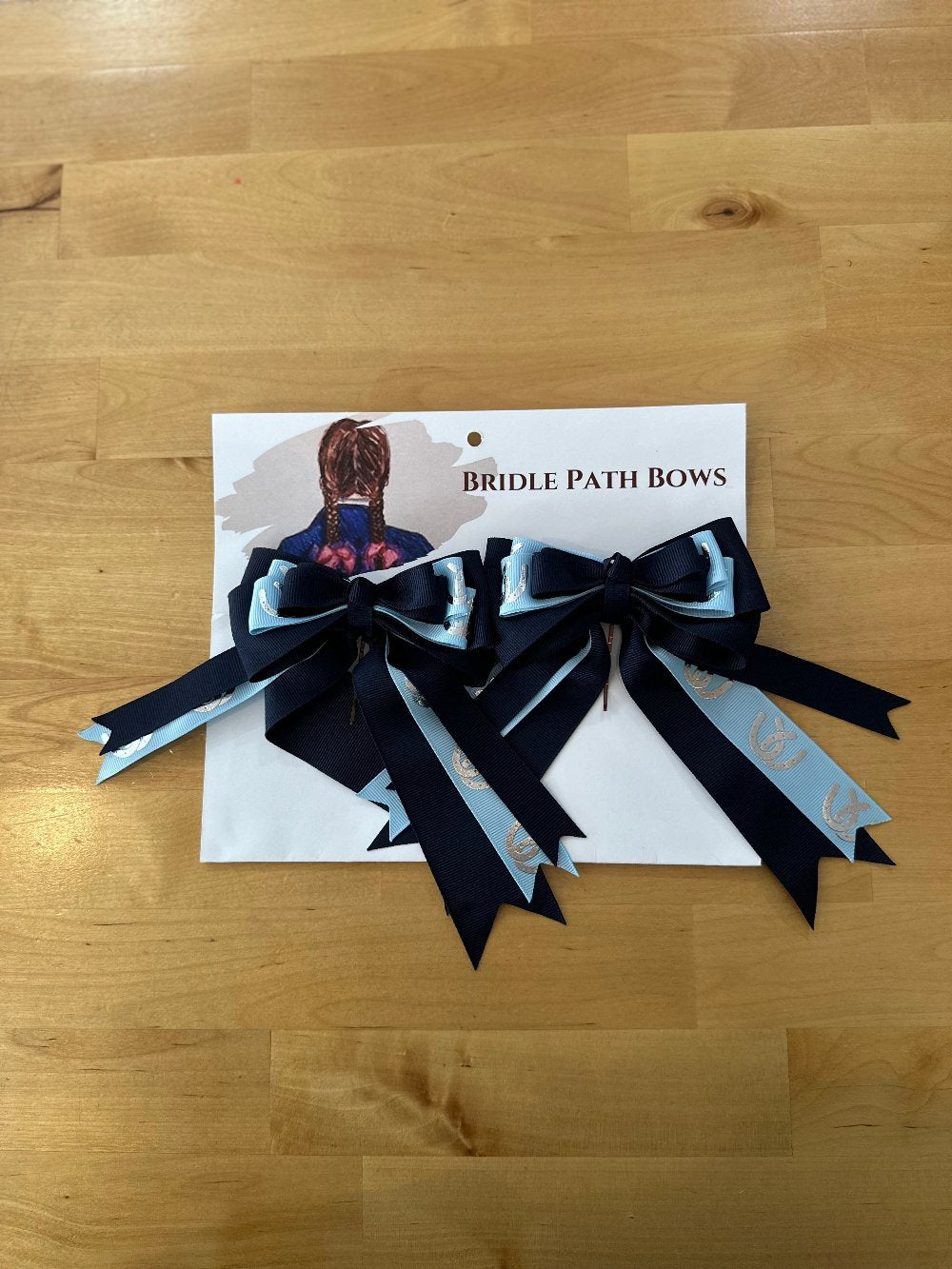 Image of children’s horse riding show bows, dark blue, light blue, silver stirrup pattern