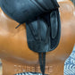 Black leather english saddle with flap lifted to expose the black billet straps