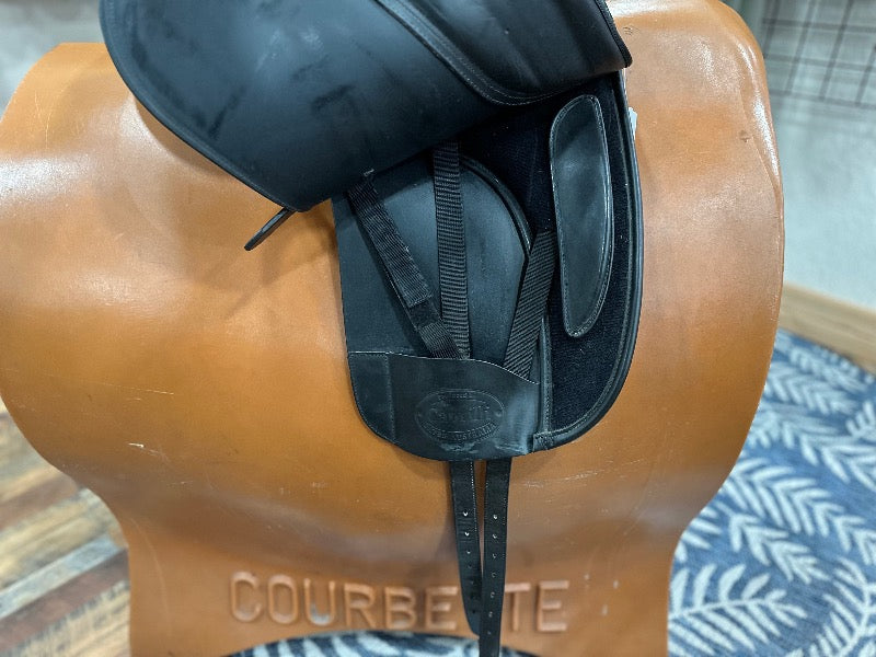 Black leather english saddle with flap lifted to expose the black billet straps