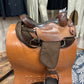 Side view of a multi toned leather and canvas western endurance saddle (no horn)