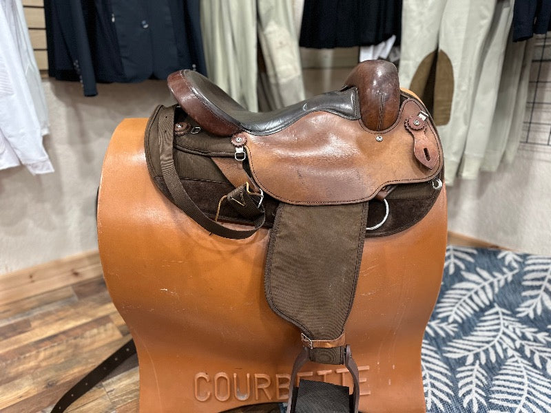 Side view of a multi toned leather and canvas western endurance saddle (no horn)