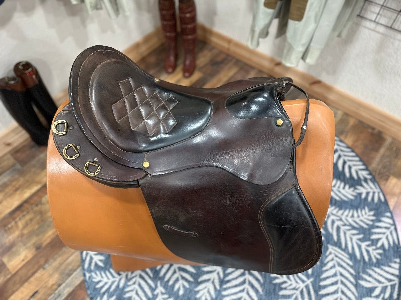 Top view of a brown leather english saddle with a wide flap and high cantle.