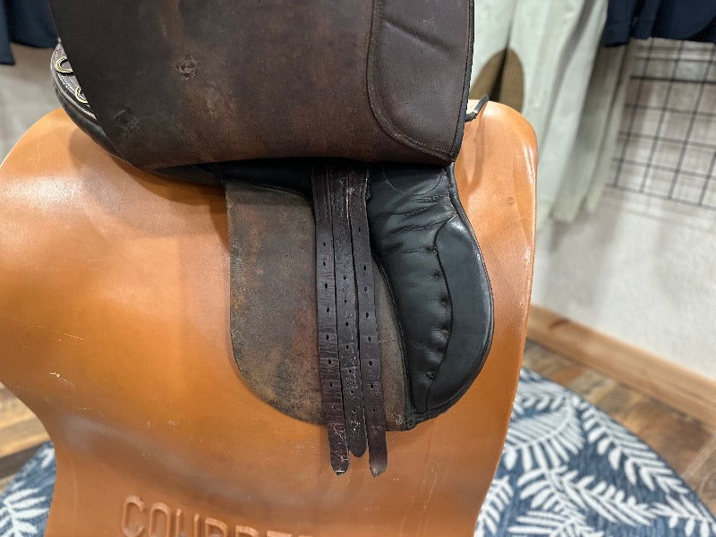 Side view of a brown leather english saddle with the flap lifted to show 3 billets in good condition
