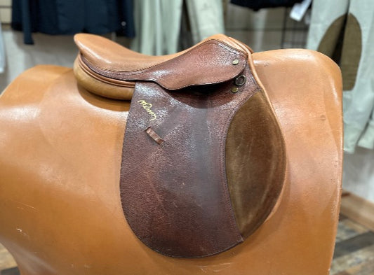 Multi toned brown leather english saddle on stand.  