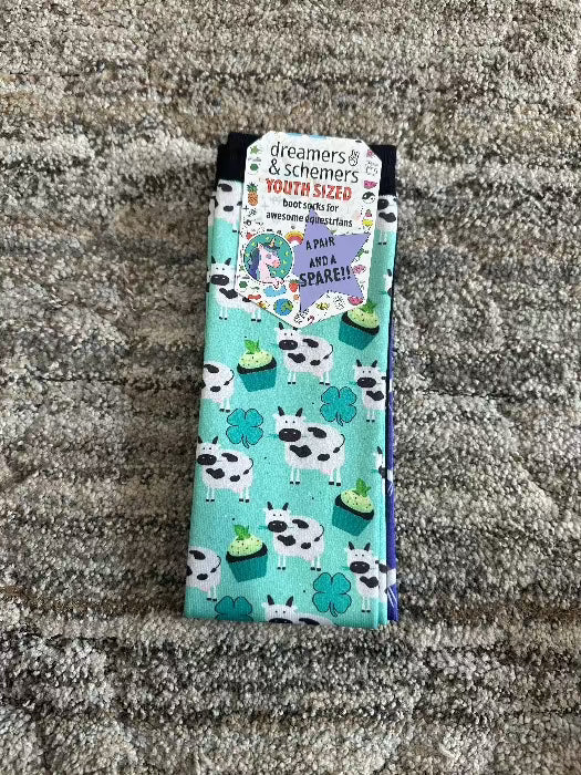 pair of socks green background with cows, clovers, cupcakes