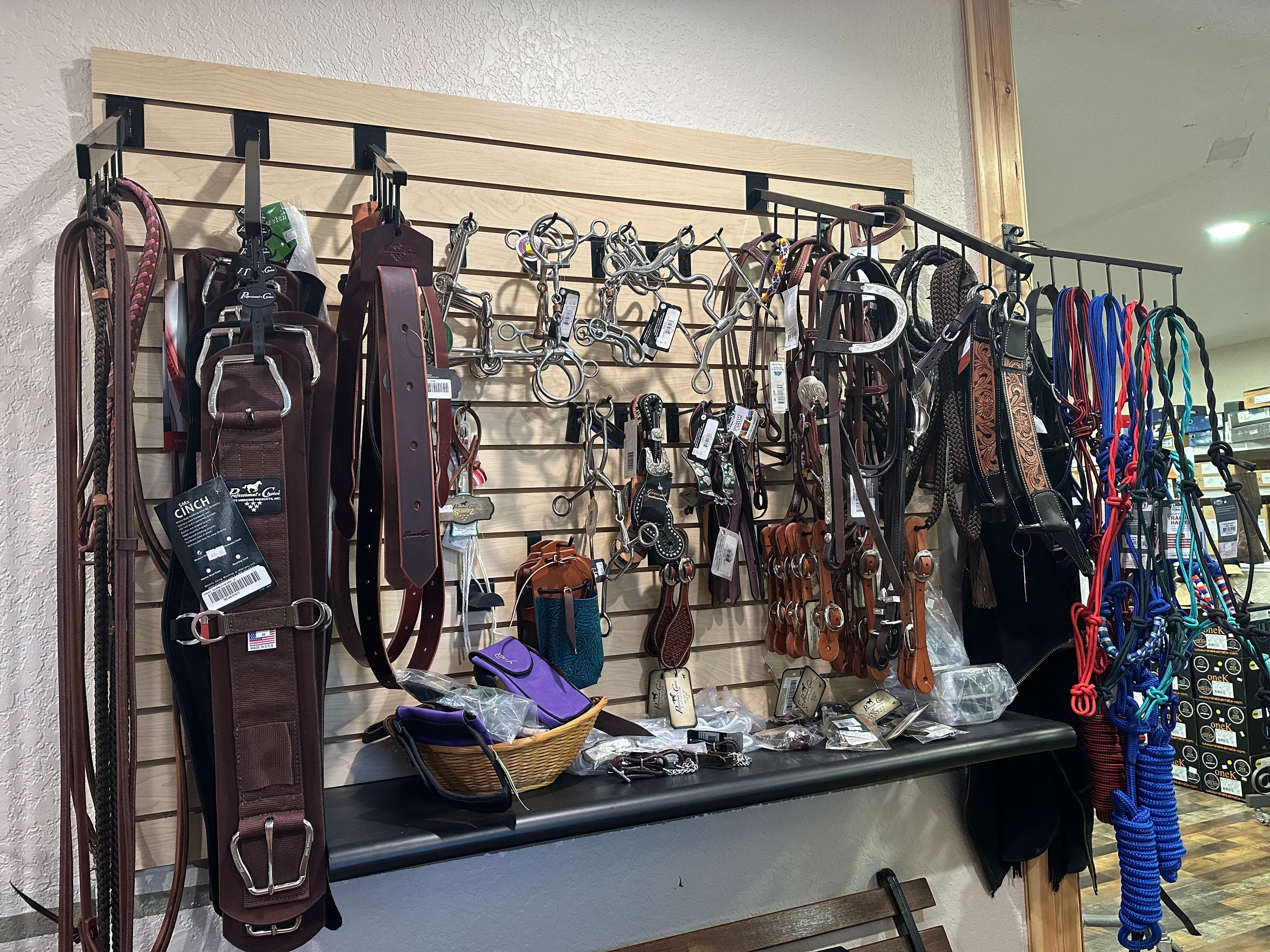 overview of western section in store from left to right, reins, girths, saddle straps, bits, spurs, spur straps , bridles, halters