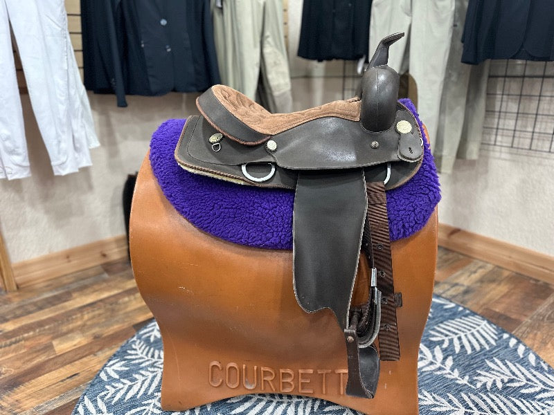 Brown western style saddle with lighter colored seat.