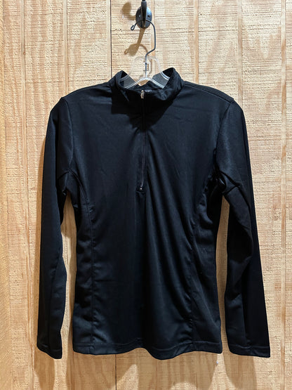 black long sleeve riding shirt hung up against light colored wood background