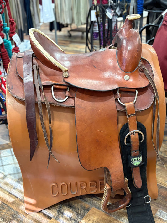 Light brown western saddle on a saddle stand.