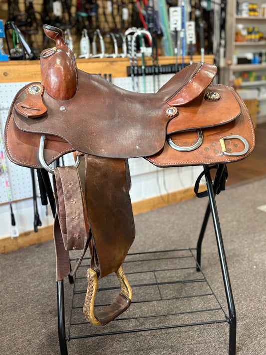 Brown leather saddle on a stand in a store setting