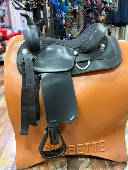 Black western saddle on a tan saddle stand