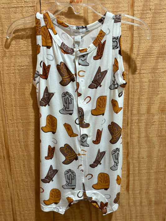 Baby romper with cowboy boot pattern on a hanger against a wooden background