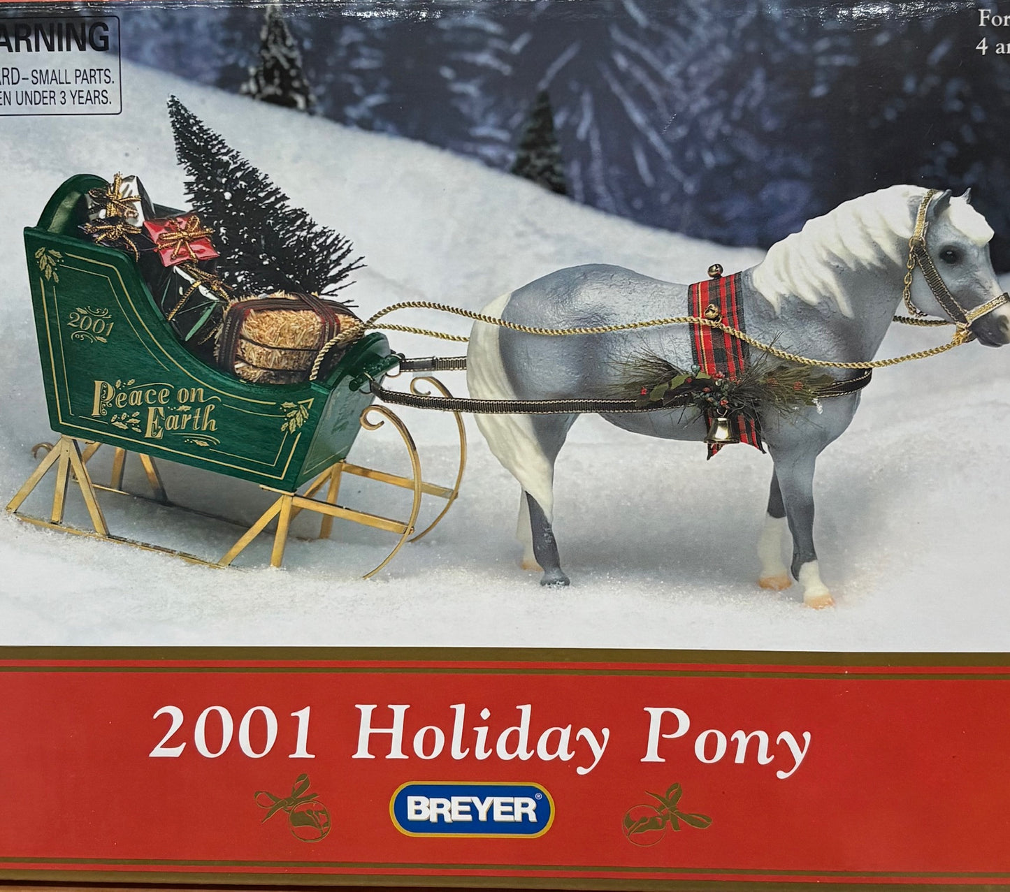 Breyer 2001 Holiday Pony with sleigh in snowy landscape, featuring Breyer branding.
