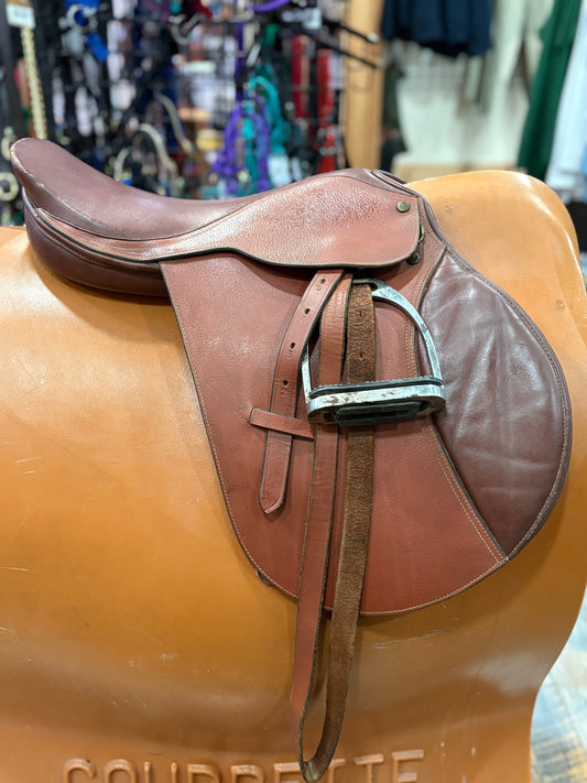 Brown leather saddle on a stand with a blurred background