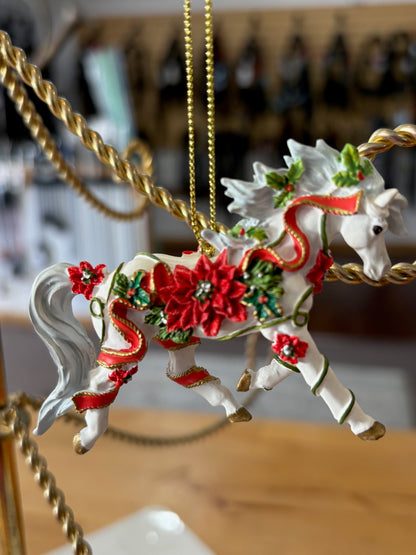 Decorative horse ornament with red flowers and gold chain on a blurred background