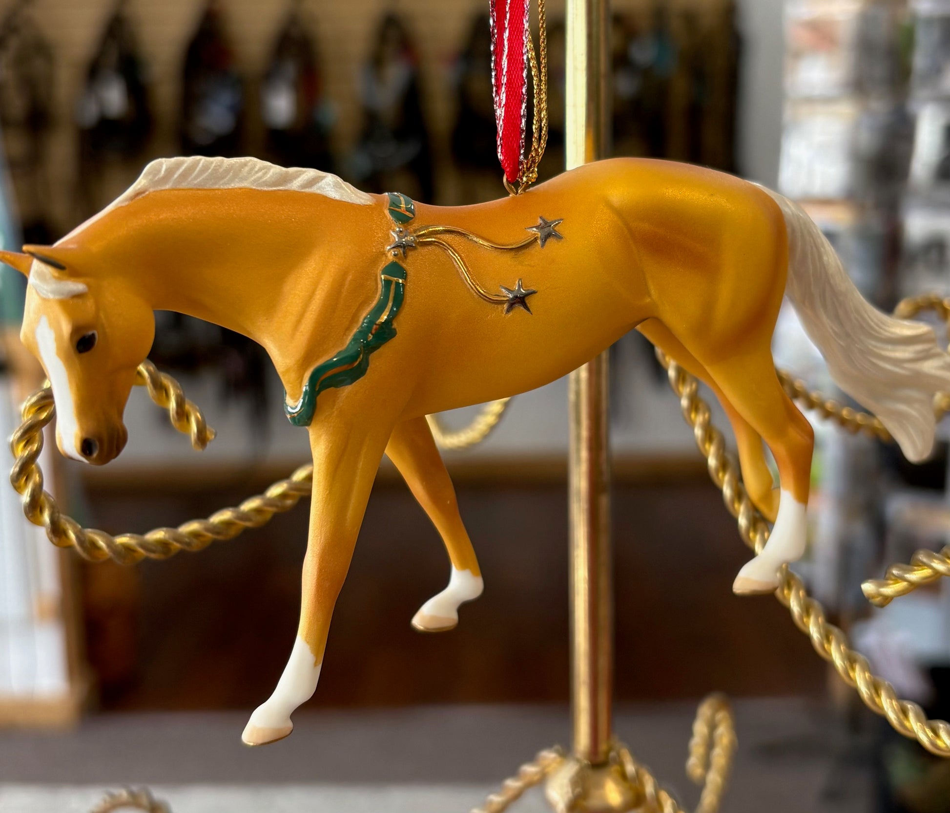 Decorative palomino horse ornament on a carousel with a blurred background