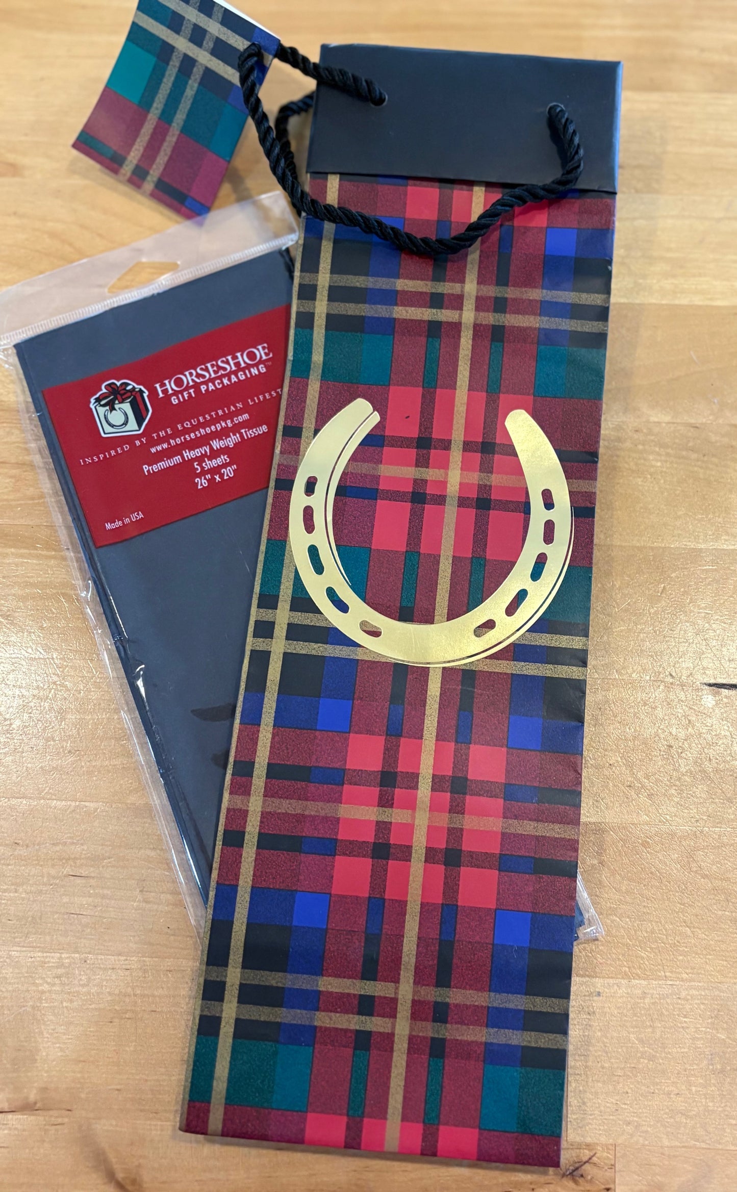 Plaid gift package with a gold horseshoe.