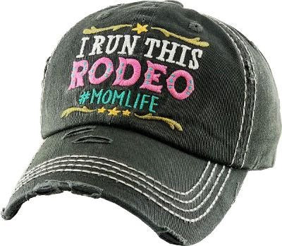 Distressed ball cap with quote on front "I run this rodeo #momlife"