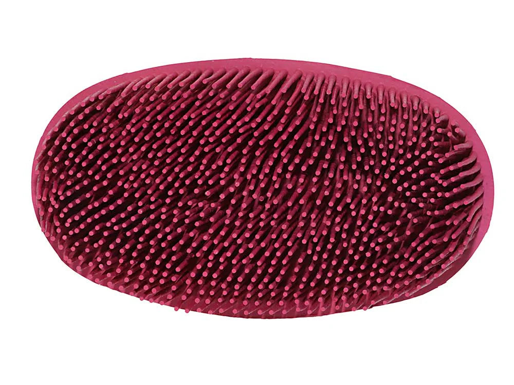 Red rubber grooming face brush with bristles on a white background