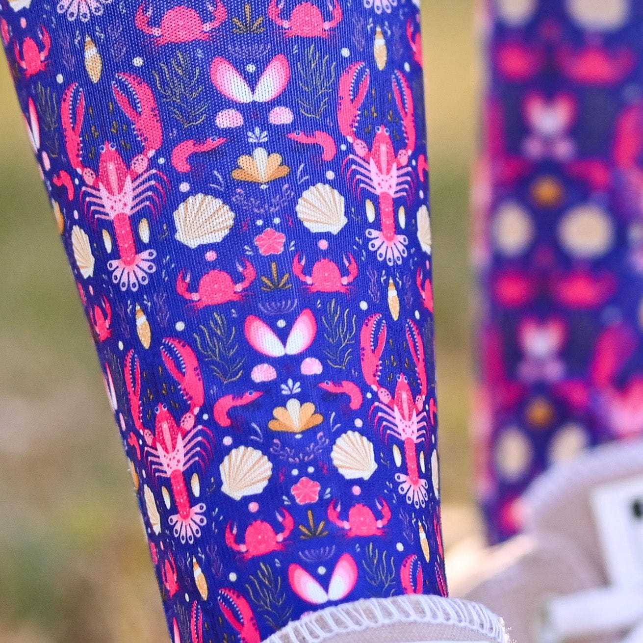 Colorful patterned knee socks with sea-themed design on a blurred background