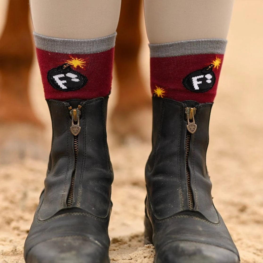 Black boots with red socks featuring a bomb design on a blurred background