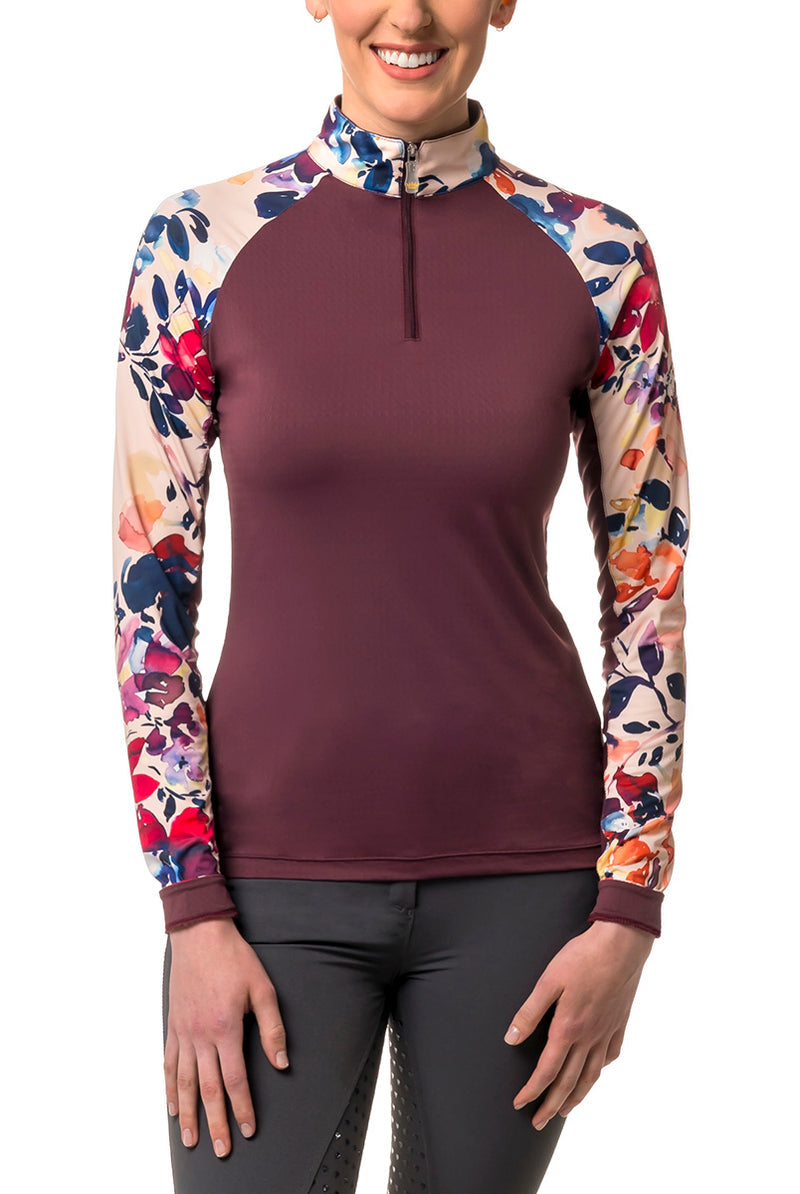 front view of purple long sleeve riding shirt with ladies hands on her thighs. with grey pants