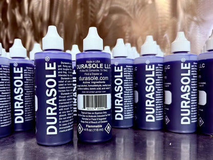 Multiple bottles of Durasole on a reflective surface with a blurred background
