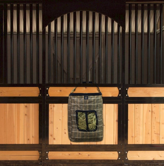Beautiful equestrian stall front with a large hay bag in traditional black and plaid tan.