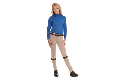 young girl modeling an equestrian riding outfit.  Tan jods with garters, paddock boots, belt and blue long sleeve riding shirt